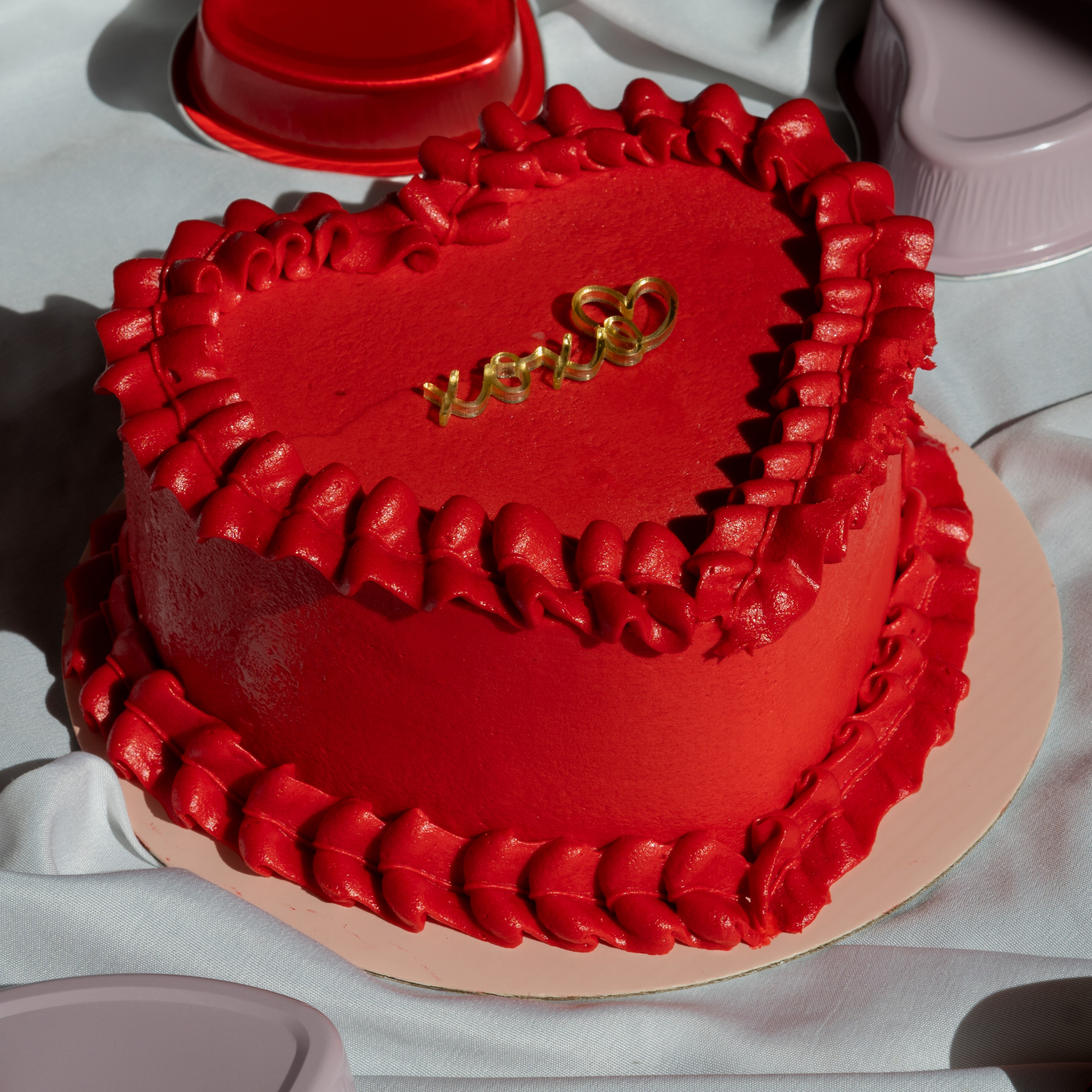 Pastel rojo en forma de corazón con texto XOXO, ideal para regalos de aniversario y parejas