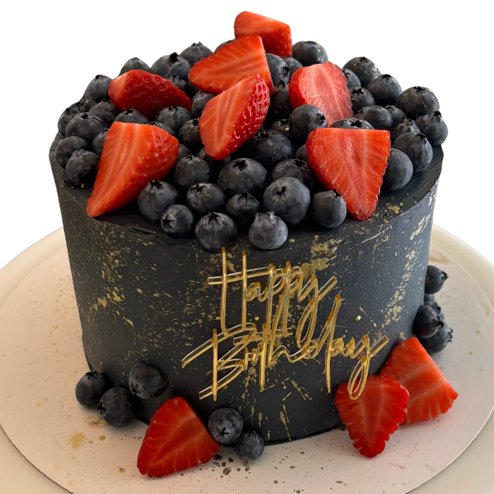 Elegante pastel de cumpleaños color negro con detalles en dorado, decorado con fresas y moras azules